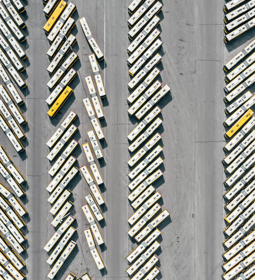 Aerial view of rows of buses in a vehicle yard.
